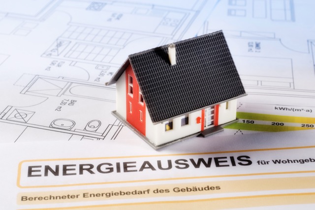 Hausmodell auf Energieausweis mit Bauplänen